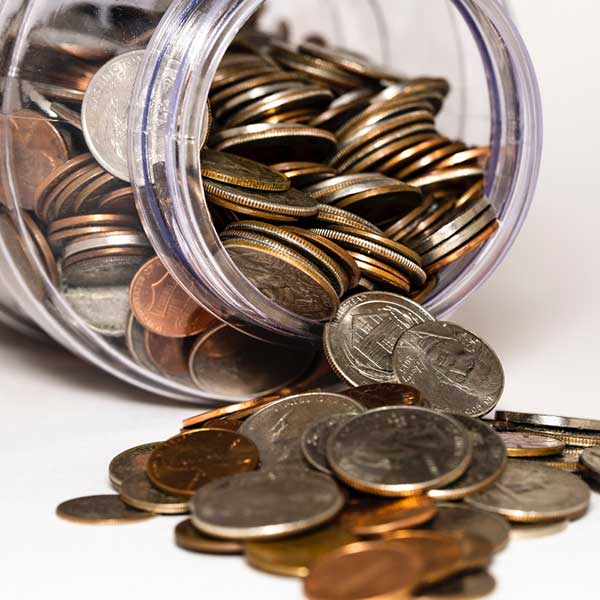Coins falling out of the jar depicting loan interest rates in the DFW Metroplex 