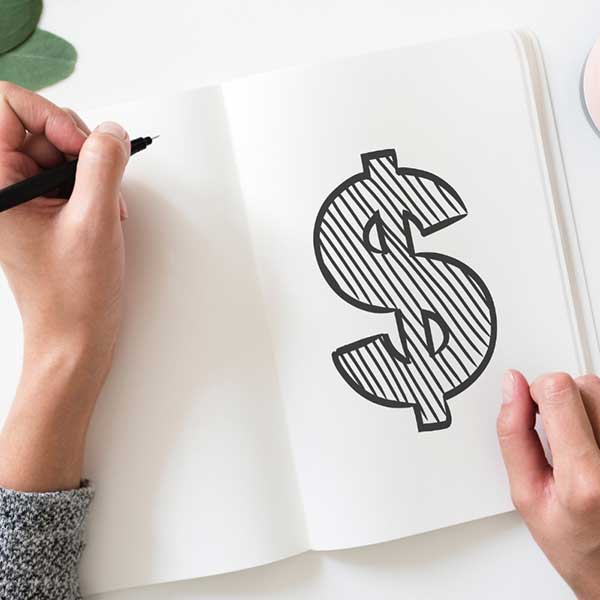 Woman painting dollar sign on paper