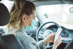 Woman wearing a face mask while driving a car in the DFW Metroplex
