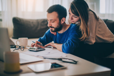 Couple sitting in their living room and checking their finances in Texas