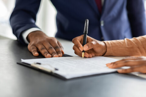 Female Customer Sign Papers In Dealership Office, Closeup Shot in DFW metroplex