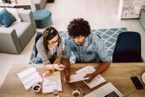 Couple sitting at table discussing finances and saving money.