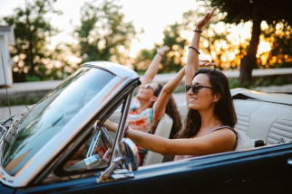 Friends enjoying an evening joyride in a vintage convertible