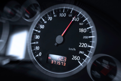The speedometer of a modern car with high miles.