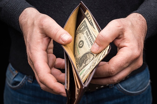 A man revealing cash inside a wallet