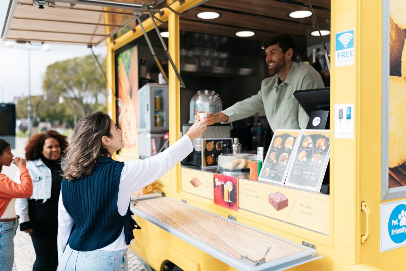 A group of smiling people enjoying food after obtaining a Food Truck Title Loan in the DFW Metroplex