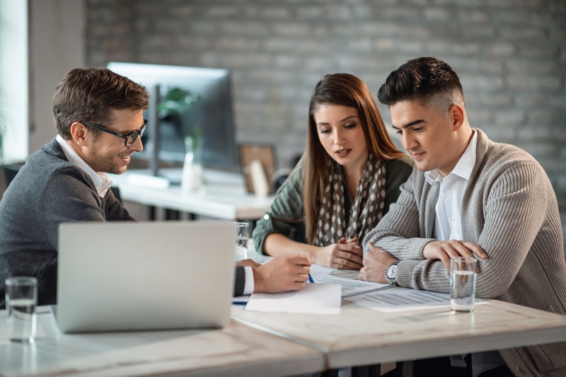 A couple consulting with a lender about a car title loan without insurance in the DFW Metroplex