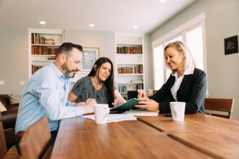 A couple meeting with a lender to review title loan options for a financed car in the DFW Metroplex